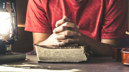 Human hand placed on the Bible, pray to God.