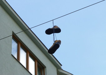 Fototapeta na wymiar Pair of old brown boots hanging on the wire