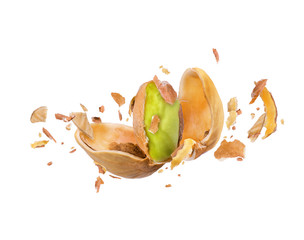 Cracked pistachio frozen in the air on a white background