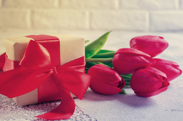 Spring bouquet of red tulips and gift box.