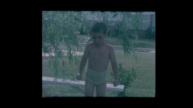 1964 Cute little boy jumps into kiddie pool