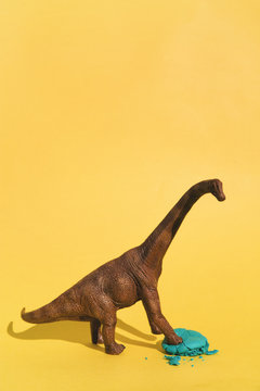 Toy dinosaur smashing macaroon