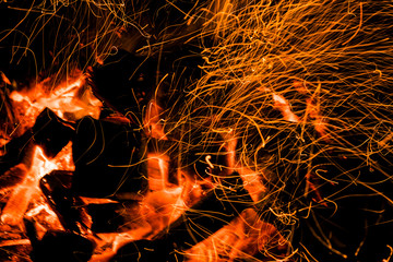 Burning firewood in the fireplace close up, BBQ fire, charcoal background. Charcoal fire with sparks