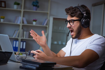 Young man playing games long hours late in the office