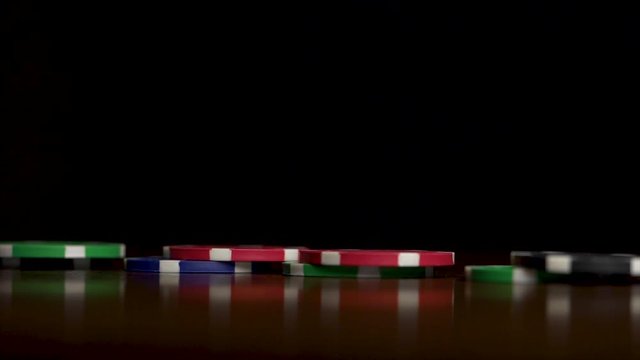 Poker chips fall like a domino effect. Poker chips standing on black background. Poker chips and domino effect