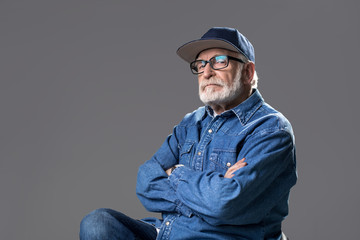 Want to look younger. Waist up portrait of bearded gaffer sitting on chair and looking at camera...