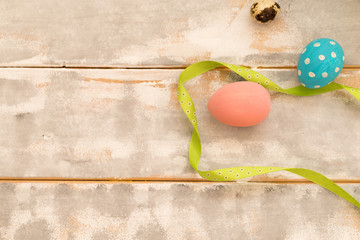 Multicolored Easter eggs and ribbons on a wooden background. Country style. Flat lay