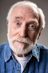 Come on. Portrait of bearded white haired male person expressing surprise. Isolated on grey background