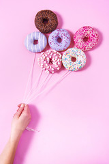 Donut ballons holding by a woman's hand. Sweetness happiness abstract conception.