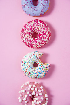 Various donuts line on a pink background. Sweetness happiness conception. 