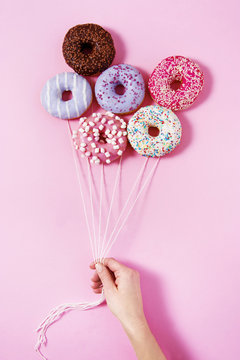 Donut ballons holding by a woman's hand. Sweetness happiness abstract conception.