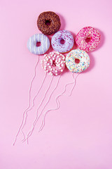 Donut ballons flying in the air. Pink background. Abstract conception.