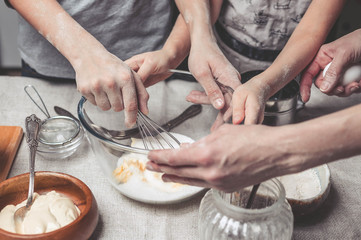 Mothers and children's hands cook dough for home-made cookies. We cook in kitchen together with children. Happy family