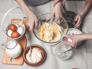 Mothers and children's hands cook dough for home-made cookies. We cook in kitchen together with children. Happy family