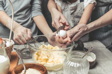 Mothers and children's hands cook dough for home-made cookies. We cook in kitchen together with children. Happy family
