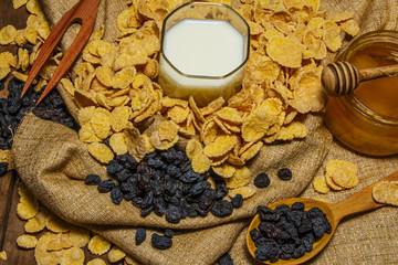 Fototapeta na wymiar Corn flakes in a bowl on a table with milk and honey for a background. Breakfast, healthy food. Selective focus.