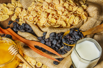 Corn flakes in a bowl on a table with milk and honey for a background. Breakfast, healthy food. Selective focus.