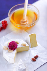 Cheese, camembert on white background, honey, red berries, apples, pears, cheese with green grapes, peanuts, pink flower, minimalism, healthy food, French breakfast