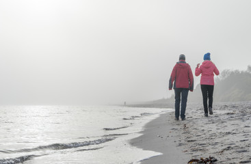 ruhiger, winterlicher, Sandstrand an der Ostseeküste im Nebel