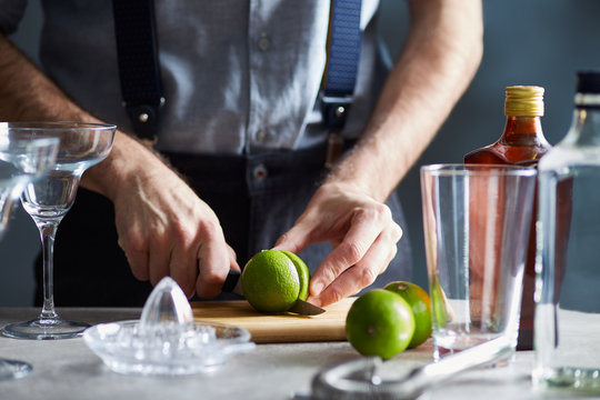 Bartender cutting lime for cocktail.