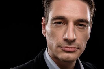 Obraz premium Top manager. Close-up of face of confident serious businessman is looking at camera single-mindedly. Isolated on black background