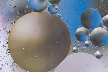 colorful oil bubbles on a water surface abstract background with blue