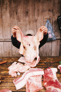 Butcher holding the face of a pig, without the skull