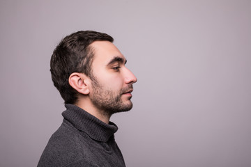 Fototapeta premium Side view portrait of thinking stylish young man looking away on gray background