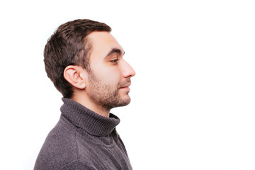 Obraz premium Side view portrait of stunning, caucasian man with bristle and crossed hands looking at copy space, standing over whute background