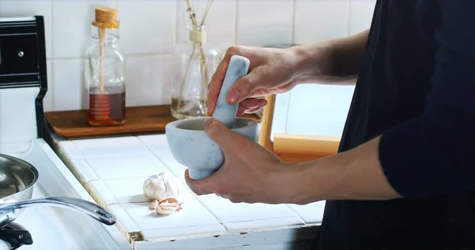Man mixing ingredients in mortar and pestle 
