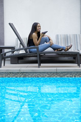 Black female on a speaker phone call in a hotel resort.  She is working while on vacation or dictating reminders on a voice assistant on her cellphone.