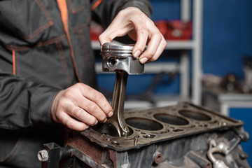 the mechanic installs a new piston. Disassemble engine block vehicle. Motor capital repair. Sixteen...