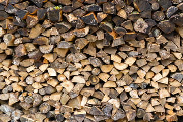 Pile firewood prepared for fireplace. Kiln-dried firewood background.