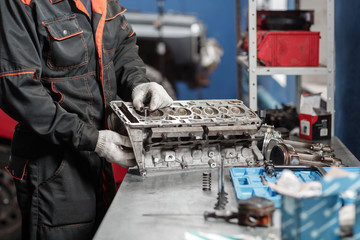 the mechanic installs a new valve. Disassemble engine block vehicle. Motor capital repair. Sixteen...