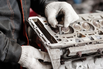 the mechanic installs a new valve. Disassemble engine block vehicle. Motor capital repair. Sixteen...