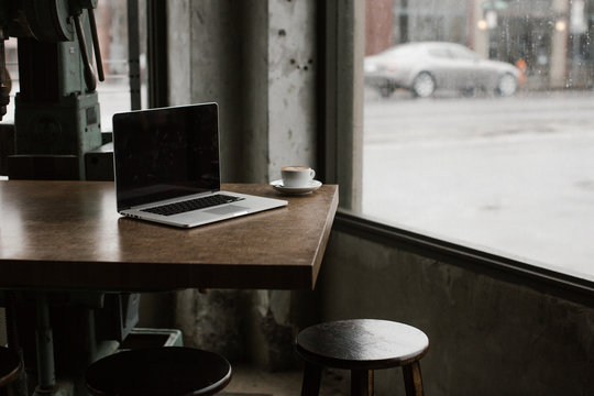 laptop on table in coffee shop with industrial feel