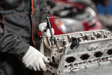 the mechanic opened the locking valve mechanism. Disassemble engine block vehicle. Motor capital...