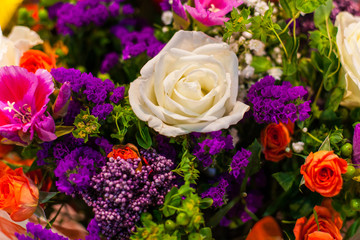 White rose among the bright flowers in the bouquet.