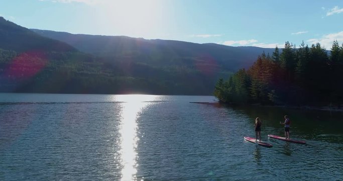 Couple rowing a stand up paddle boad in the river 