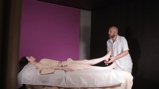 Wellness foot massage. Close up of osteopath doing manipulative massage. Man hands massaging female. Spa centre concept