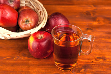 fresh red apples in wicker basket on wooden table