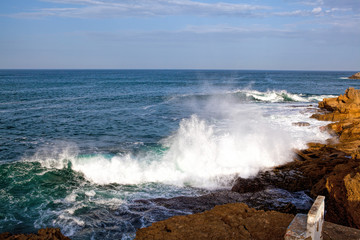 Sea waves crashing against the rocks .