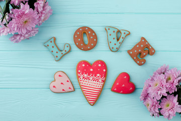 Heart shaped cookies for Valentine Day. Pink flowers and letter cookies for Valentine Day. Valentine Day wooden greeting background.