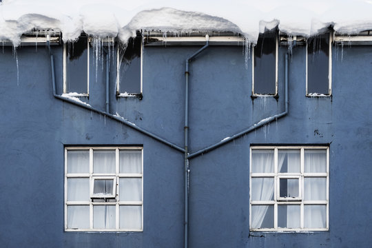 Blue Facade Of A House In Reykjavik With Heavy Snow On Roof