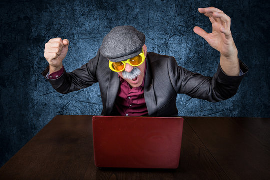 Alter Mann sitzt gereizt am Computer und &auml;rgert sich 