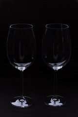 Two empty wine glass on black background. Fragile blank glasses for wine on dark background. Romance and celebration.