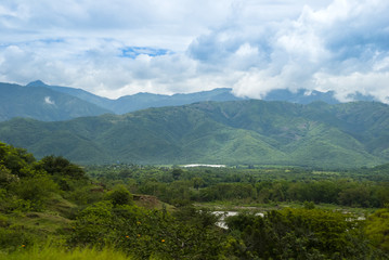 Summer landscape with mountains, cloudy sky, green grass and trees in Guatemala.