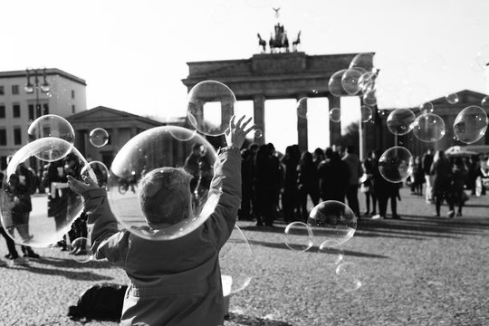 Rear view of&nbsp;boy playing with bubbles in front of the Brandenburg Gate