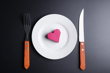 Box red heart shape in the white dish on black background with copy space.Valentine's Day, Day of love.