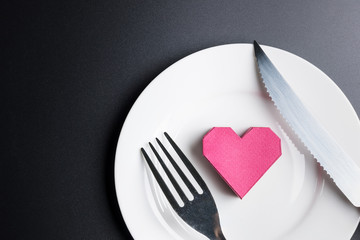 Box red heart shape in the white dish on black background with copy space.Valentine's Day, Day of love.